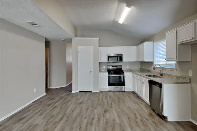 a kitchen with stainless steel appliances a refrigerator and a stove top oven