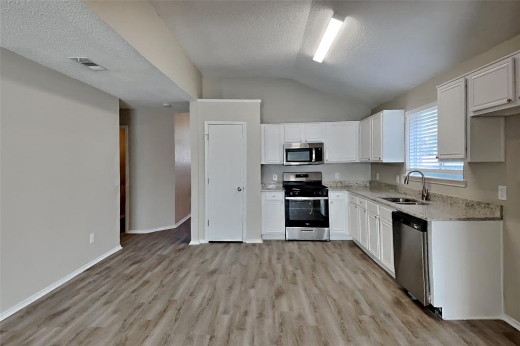 1924 Overland Street Fort Worth, TX 76131 - Photo 5 of 27 a kitchen with stainless steel appliances a refrigerator and a stove top oven