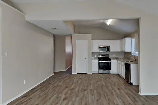 a kitchen with a refrigerator and a stove top oven
