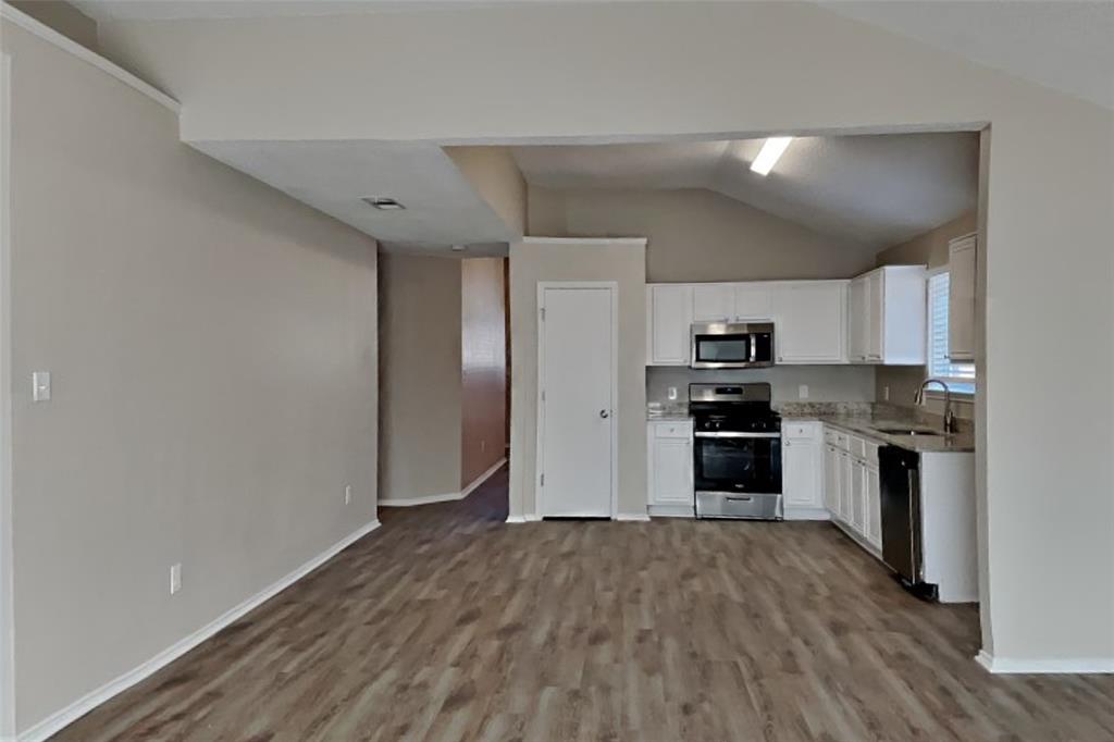 1924 Overland Street Fort Worth, TX 76131 - Photo 8 of 27 a kitchen with a refrigerator and a stove top oven