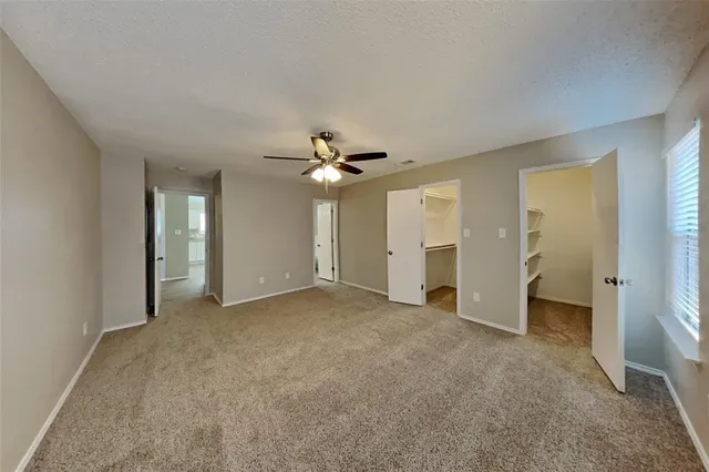 an empty room with fan and entrance