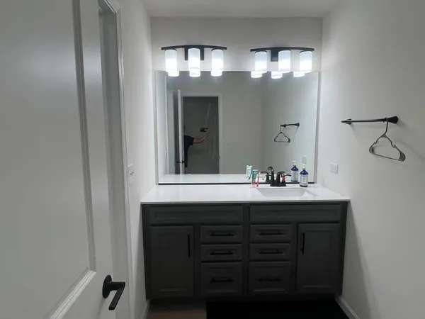 a bathroom with a sink vanity and mirror