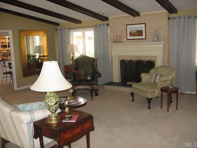 7229 Kemp Road Raleigh, NC 27613 - Photo 7 of 12 a living room with furniture a table and a fireplace