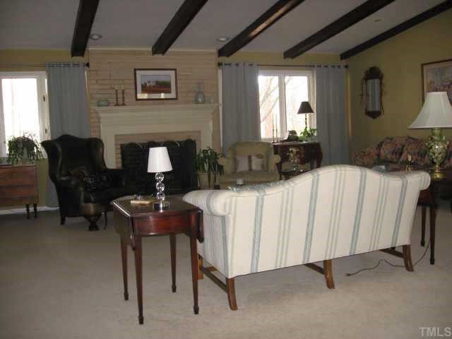 7229 Kemp Road Raleigh, NC 27613 - Photo 9 of 12 a living room with furniture a fireplace and a large window
