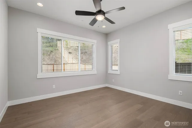 an empty room with a window and a fan