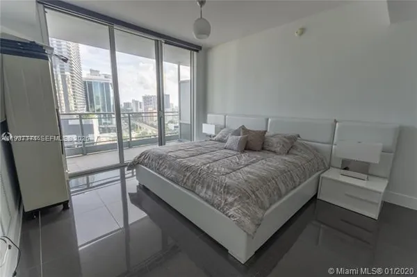 a bedroom with a bed and a large window