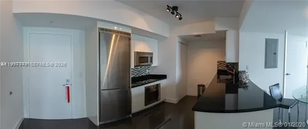a kitchen with stainless steel appliances granite countertop a refrigerator and a sink