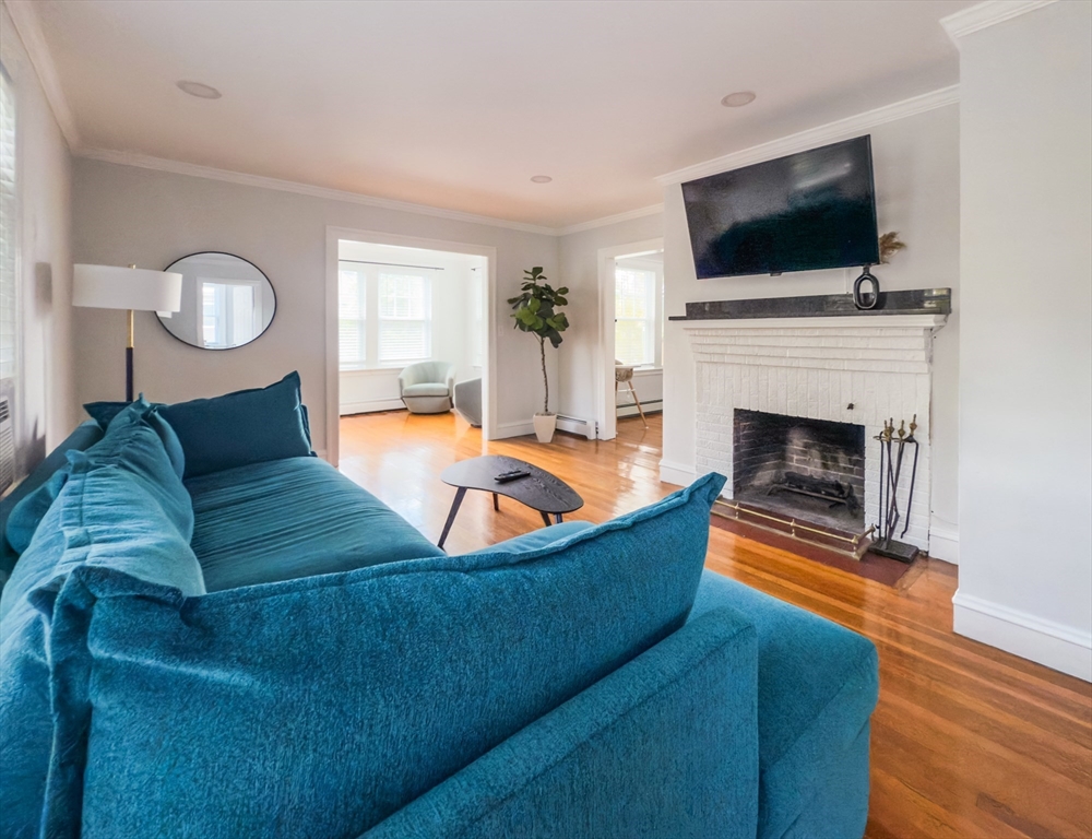 65-67 St James Circle, Unit 2 Newton, MA 02458 - Photo 3 of 29 a living room with furniture fireplace and flat screen tv