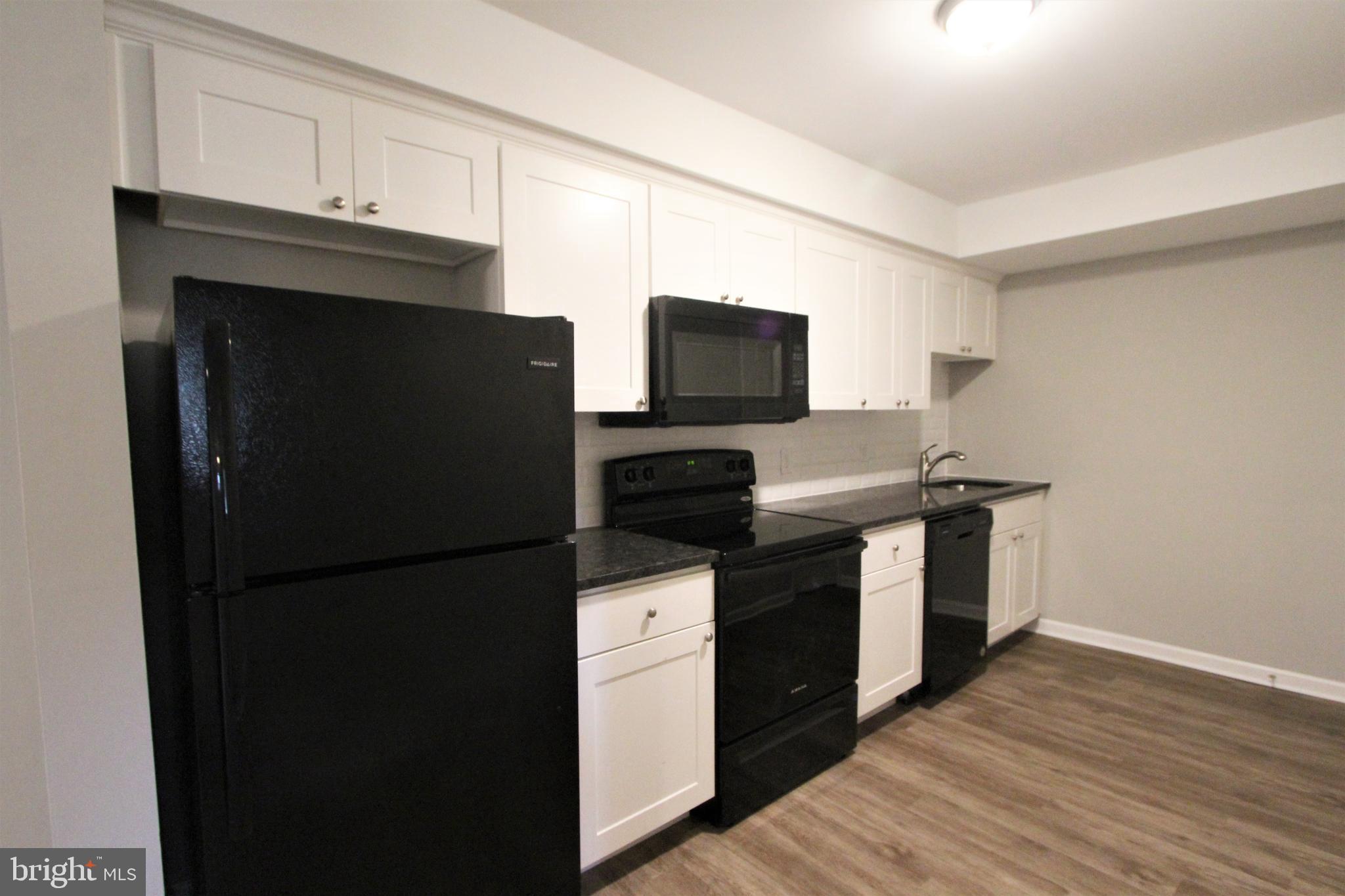 6640 Sprague Street, Unit B5 Philadelphia, PA 19119 - Photo 3 of 16 a kitchen with a refrigerator stove and microwave