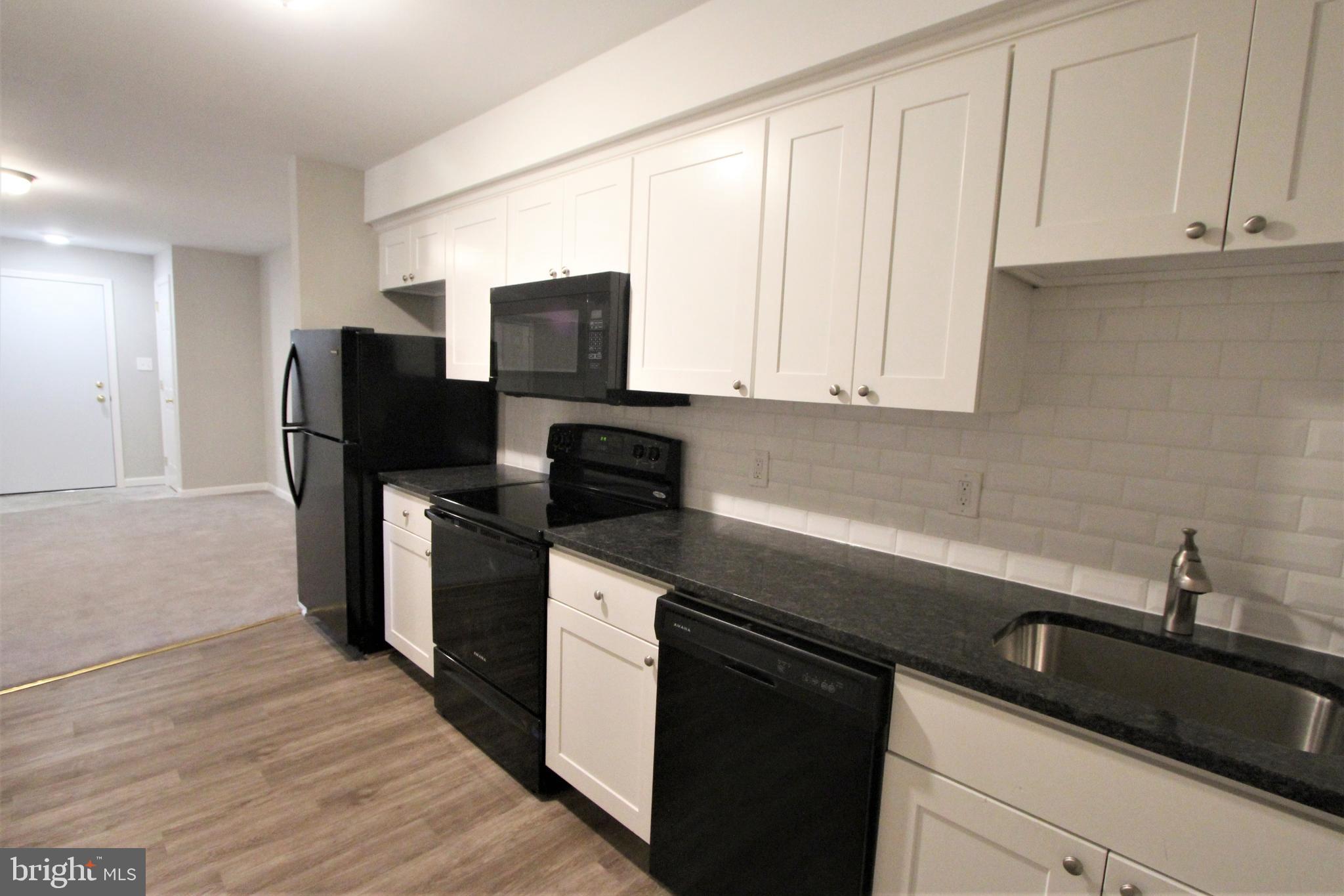 6640 Sprague Street, Unit B5 Philadelphia, PA 19119 - Photo 4 of 16 a kitchen with a sink dishwasher a refrigerator and cabinets