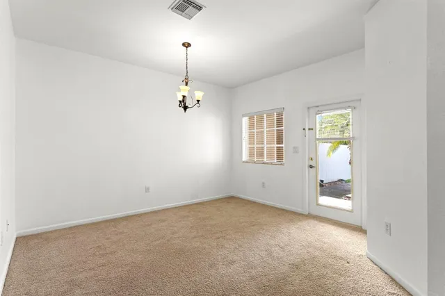 an empty room with windows and ceiling fan