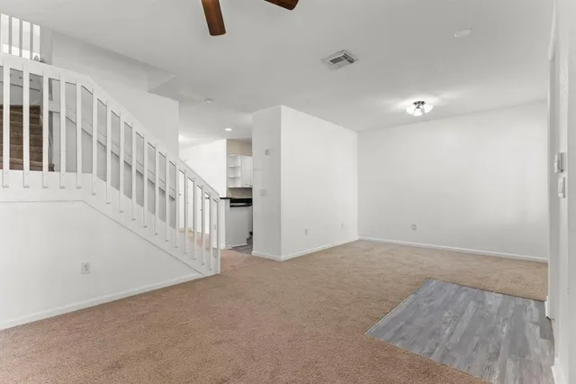 a view of a hallway with wooden floor and stairs