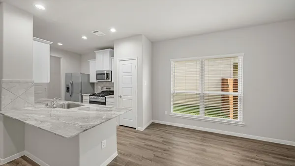 a kitchen with kitchen island a sink appliances and cabinets