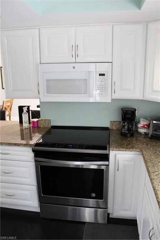 7328 Pebble Beach Road Fort Myers, FL 33967 - Photo 16 of 31 a kitchen with stainless steel appliances granite countertop white cabinets and a stove