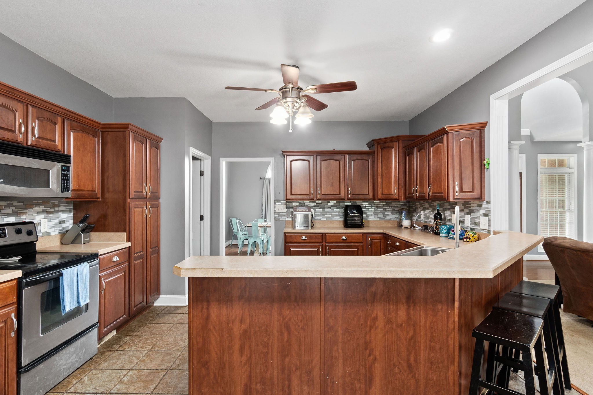 2458 Carroll Road Palmyra, TN 37142 - Photo 14 of 35 a kitchen with a stove a sink a refrigerator dining table and chairs