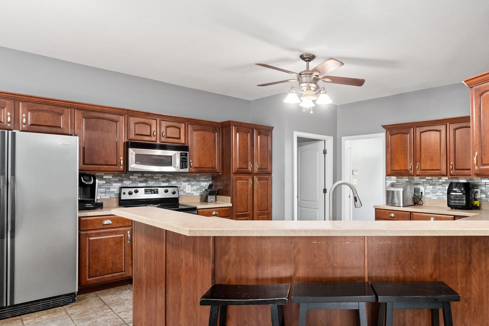 2458 Carroll Road Palmyra, TN 37142 - Photo 10 of 35 a kitchen with stainless steel appliances a stove a sink refrigerator dining table and chairs
