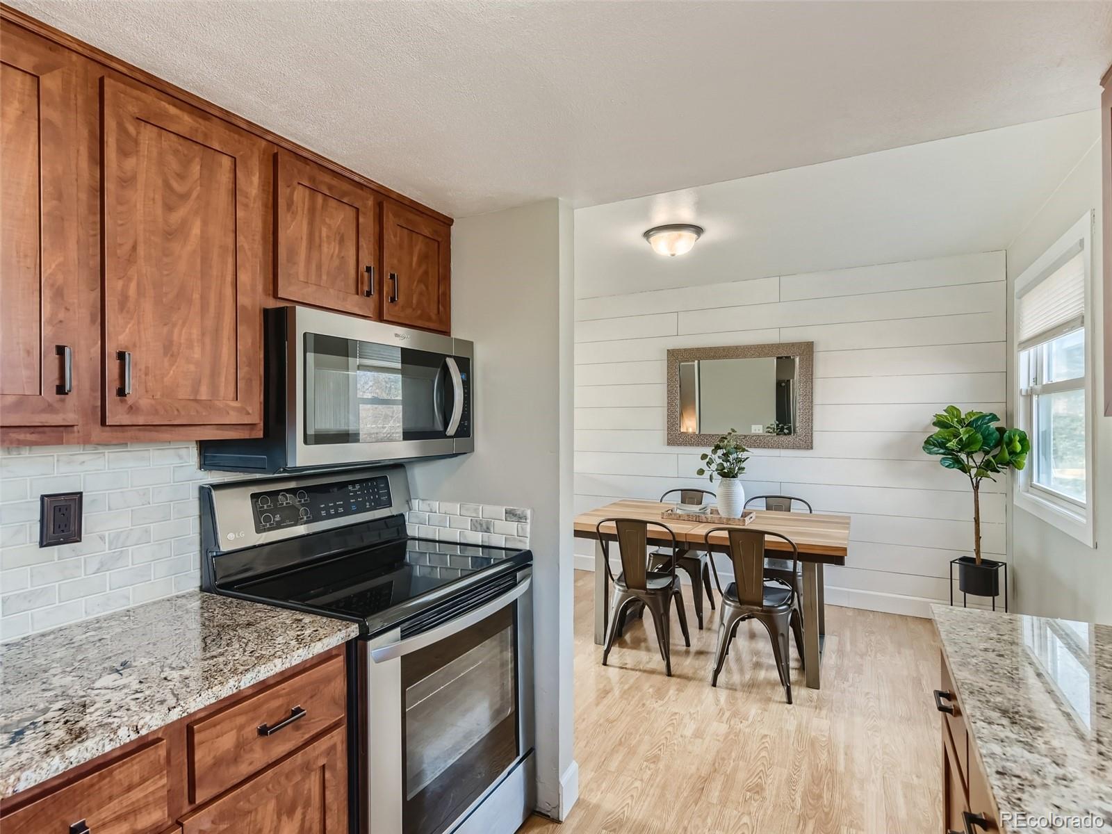 10390 Owens Circle Westminster, CO 80021 - Photo 11 of 28 a kitchen with stainless steel appliances granite countertop a stove a sink a microwave and a refrigerator