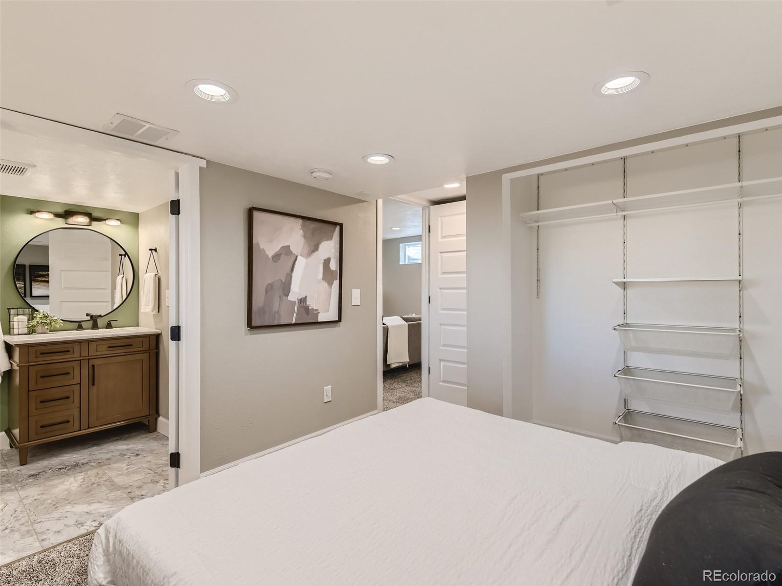 10390 Owens Circle Westminster, CO 80021 - Photo 24 of 28 a bedroom with a large bed and vanity