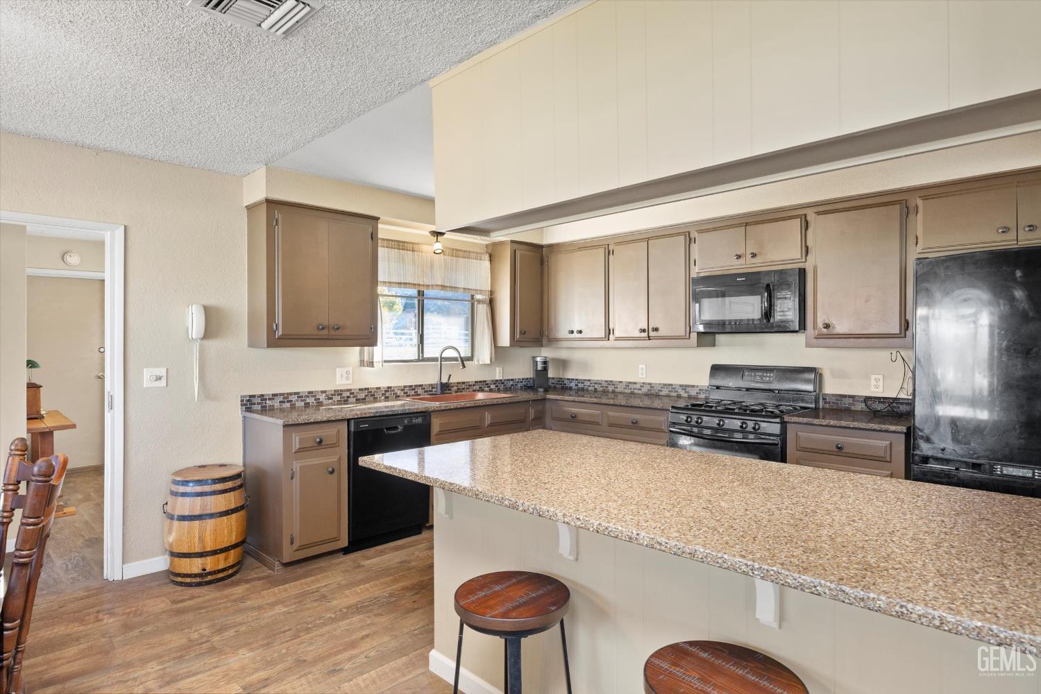 Undisclosed Address Tehachapi, CA 93561 - Photo 14 of 40 a large kitchen with stainless steel appliances granite countertop a stove a sink a microwave and a refrigerator