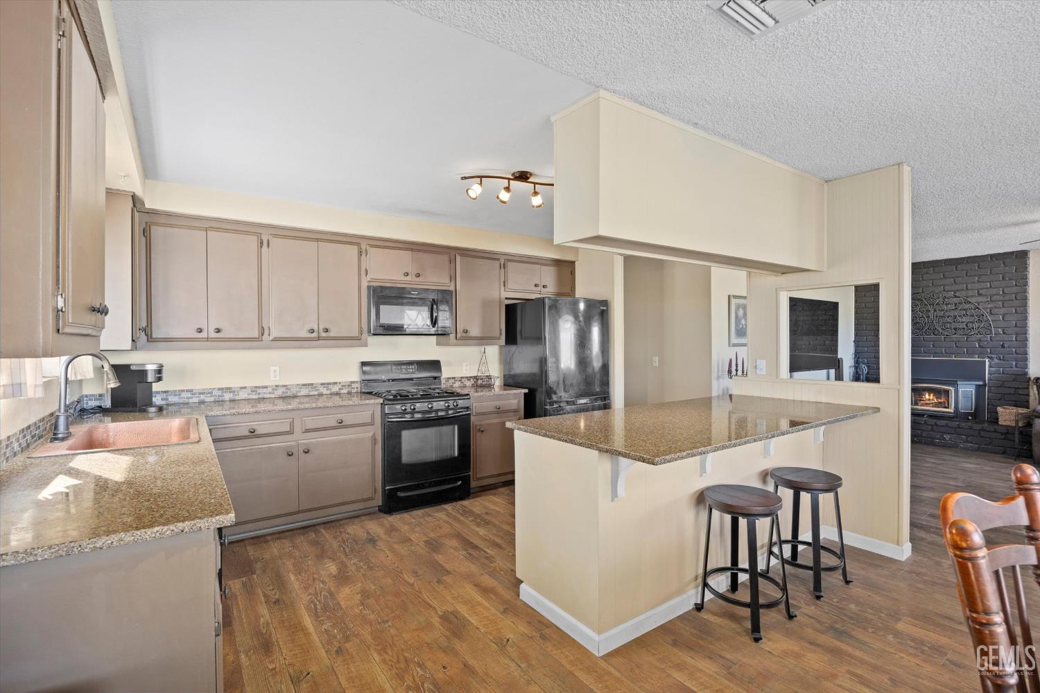 Undisclosed Address Tehachapi, CA 93561 - Photo 15 of 40 a kitchen with a refrigerator a stove top oven a sink dishwasher and white cabinets with wooden floor