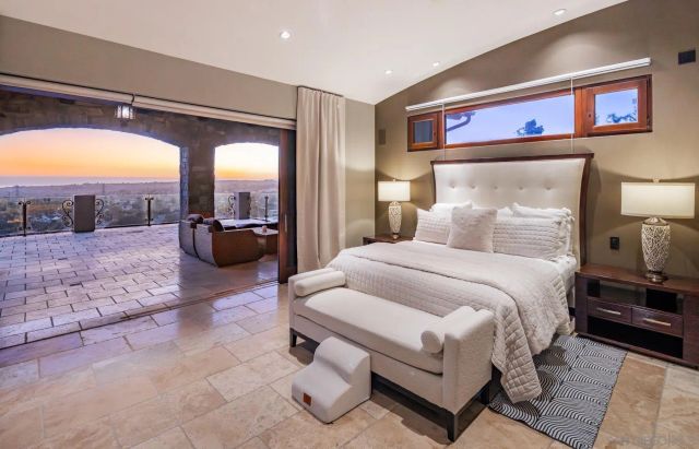 a spacious bedroom with a bed and glass walk in closet