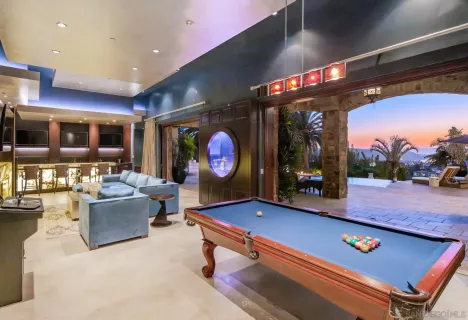 a living room with furniture a pool table and a fireplace