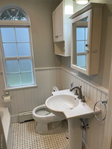 a bathroom with a sink a toilet and mirror