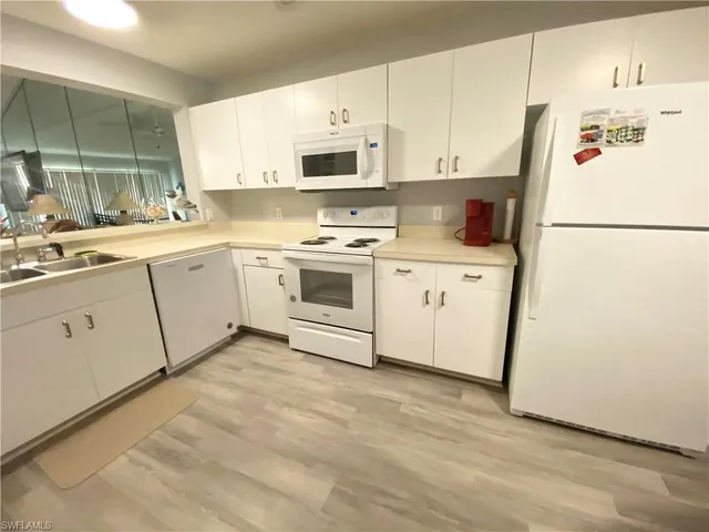 a kitchen with appliances a sink and a refrigerator