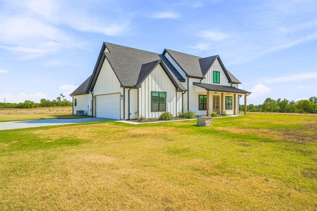 8140 Lavender Road Springtown, TX 76082 - Photo 4 of 40 Modern farmhouse exterior with vertical white siding, black-framed windows, and a covered porch with wooden posts