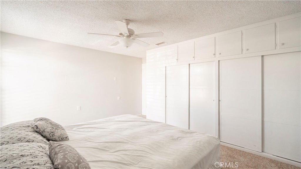 1880 St John Road Seal Beach, CA 90740 - Photo 25 of 30 a bedroom with a bed and a ceiling fan