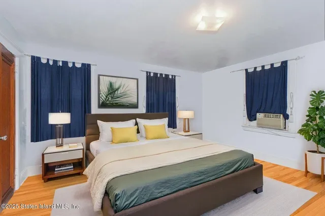 a bedroom with a bed table and a potted plant