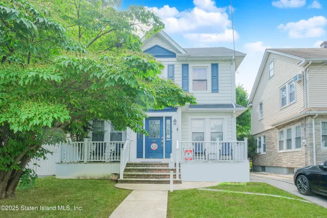 a view of a house with a yard and sitting area