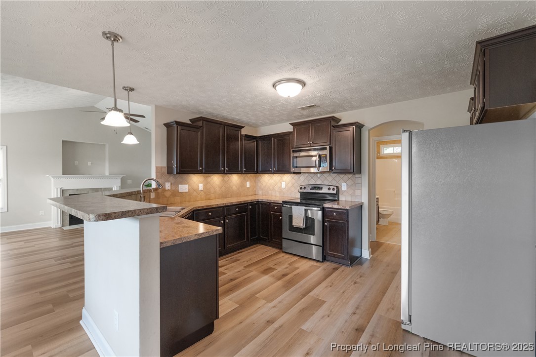 203 United Road Raeford, NC 28376 - Photo 11 of 36 a kitchen with granite countertop a stove top oven a sink dishwasher a refrigerator and wooden floor