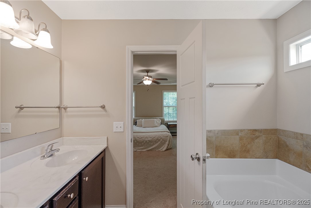 203 United Road Raeford, NC 28376 - Photo 16 of 36 a bathroom with a tub sink and mirror