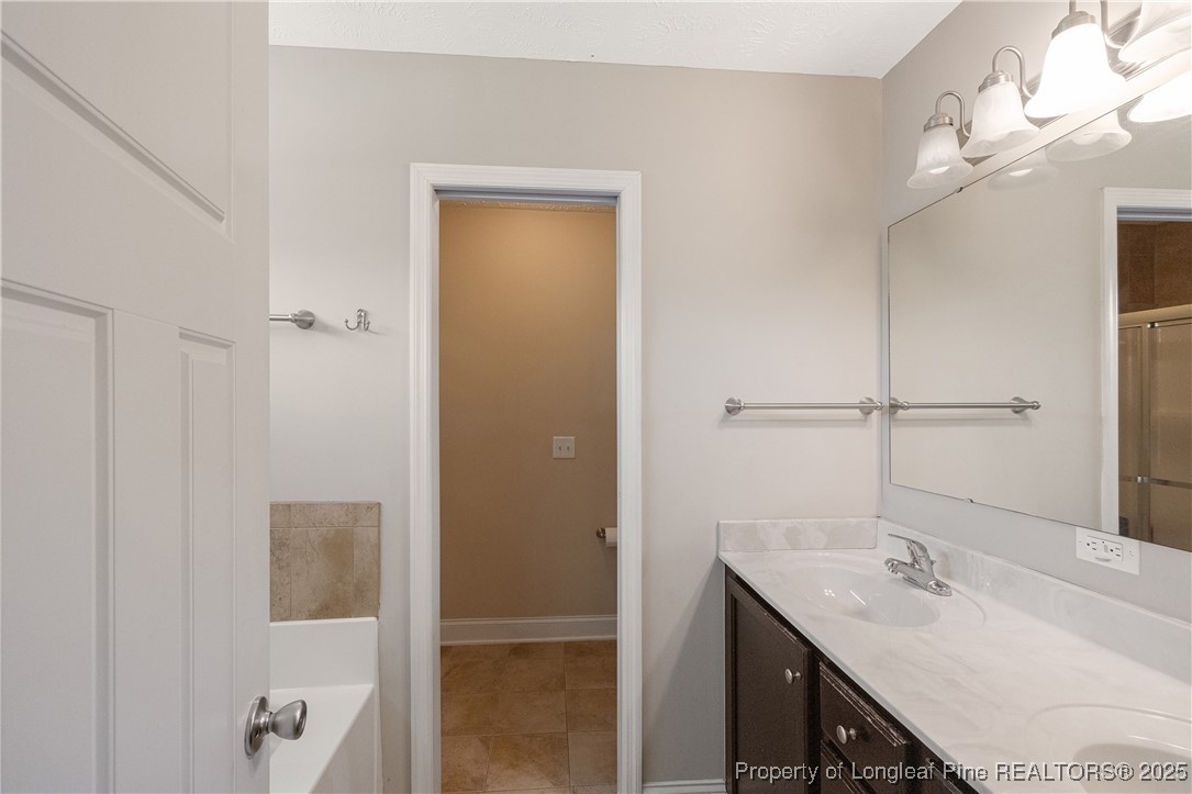 203 United Road Raeford, NC 28376 - Photo 17 of 36 a bathroom with a granite countertop sink a mirror and shower
