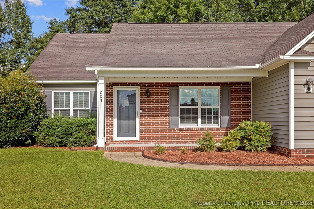 203 United Road Raeford, NC 28376 - Photo 2 of 36 a front view of a house with a yard and plants
