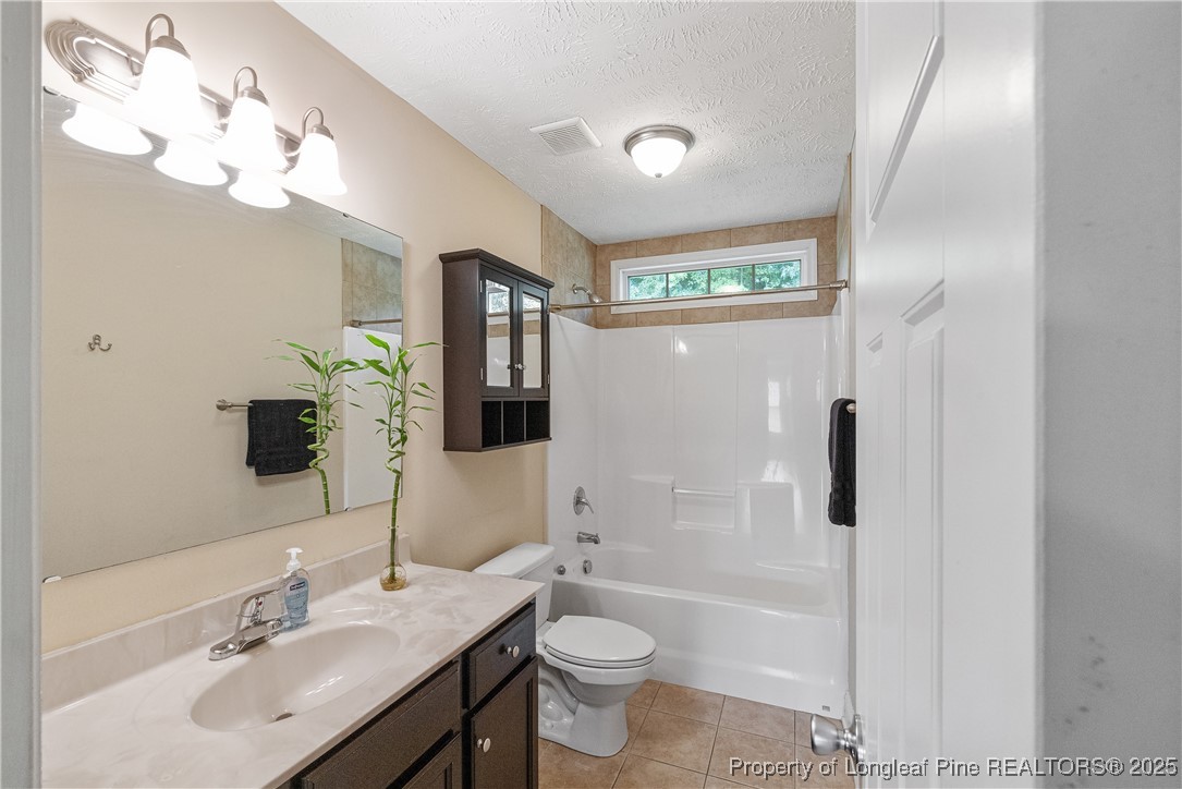 203 United Road Raeford, NC 28376 - Photo 21 of 36 a bathroom with a toilet a sink a tub and mirror