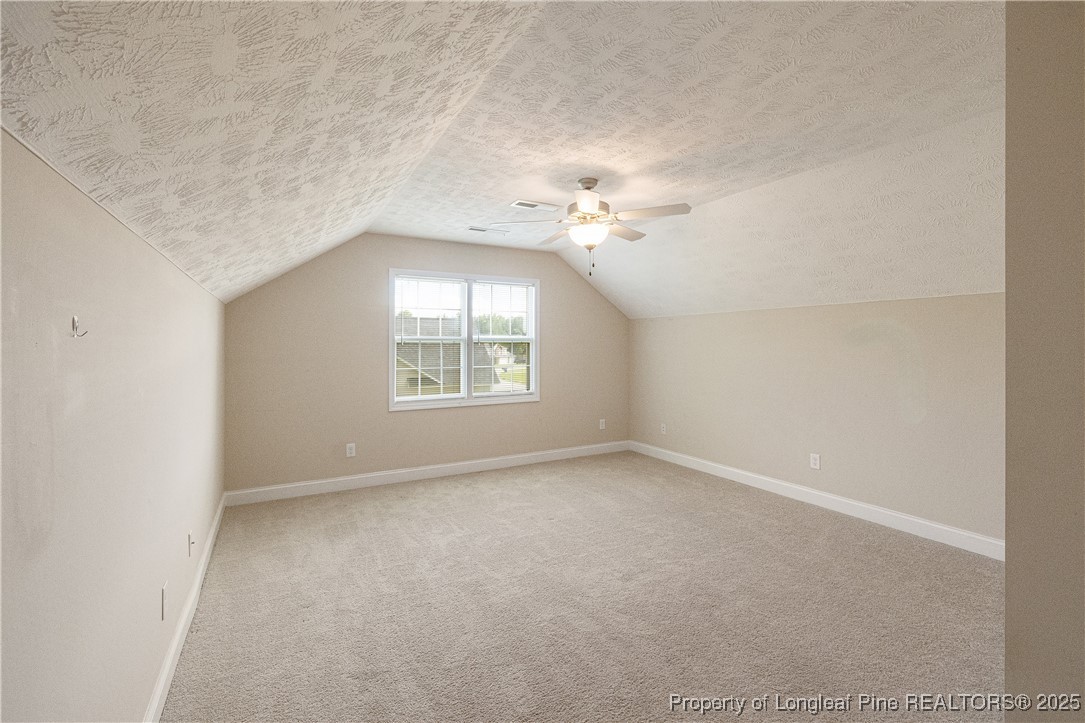 203 United Road Raeford, NC 28376 - Photo 25 of 36 an empty room with a chandelier fan and windows
