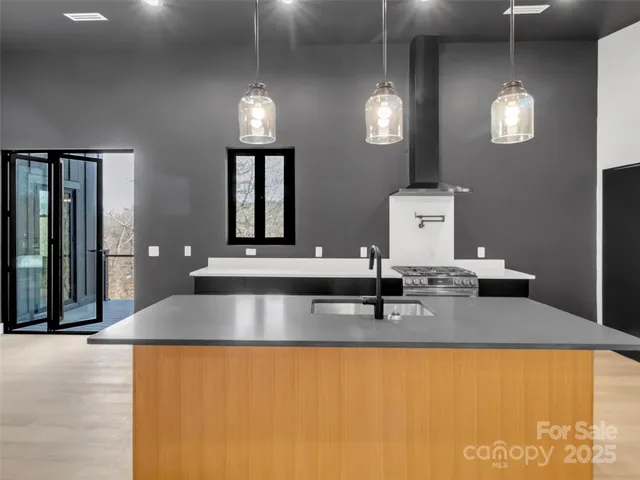 a large kitchen with kitchen island granite countertop a refrigerator oven a sink and dishwasher