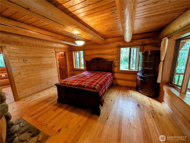 a bedroom with a bed and wooden floor