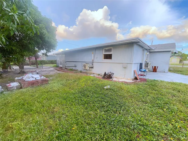a view of a backyard with table and chairs and potted plants