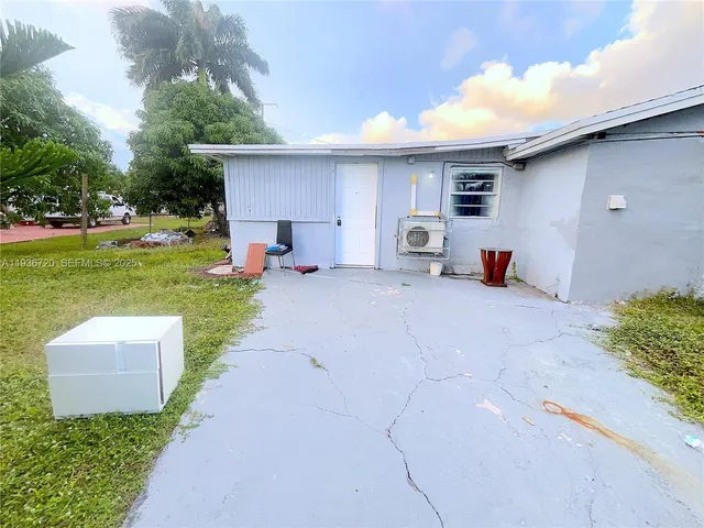a view of a patio with table and chairs under an umbrella