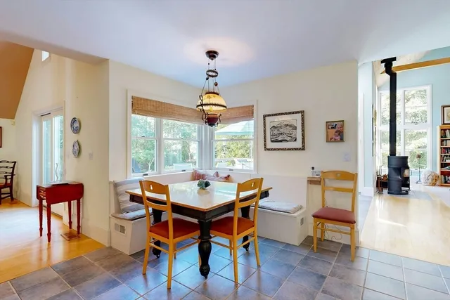 a dining room with wooden floor and a chandelier