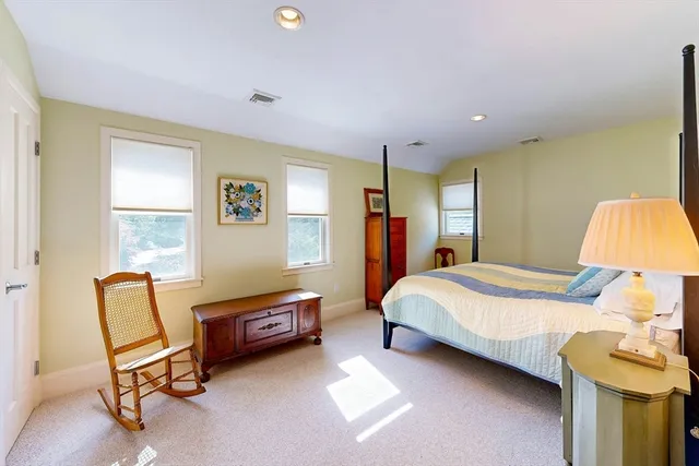 a bedroom with a bed chair and a window