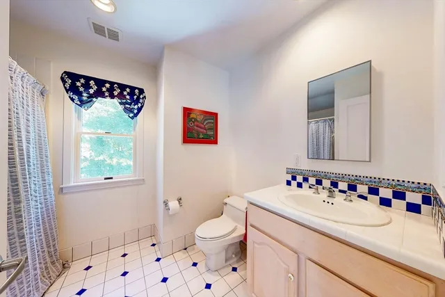 an aerial view of a city with lots of residential buildings and green landscape