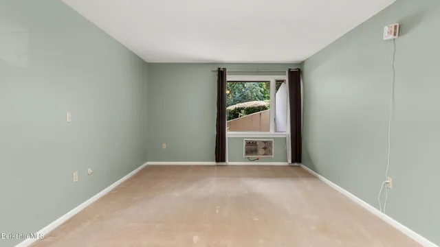 a view of an empty room with a fireplace and a window
