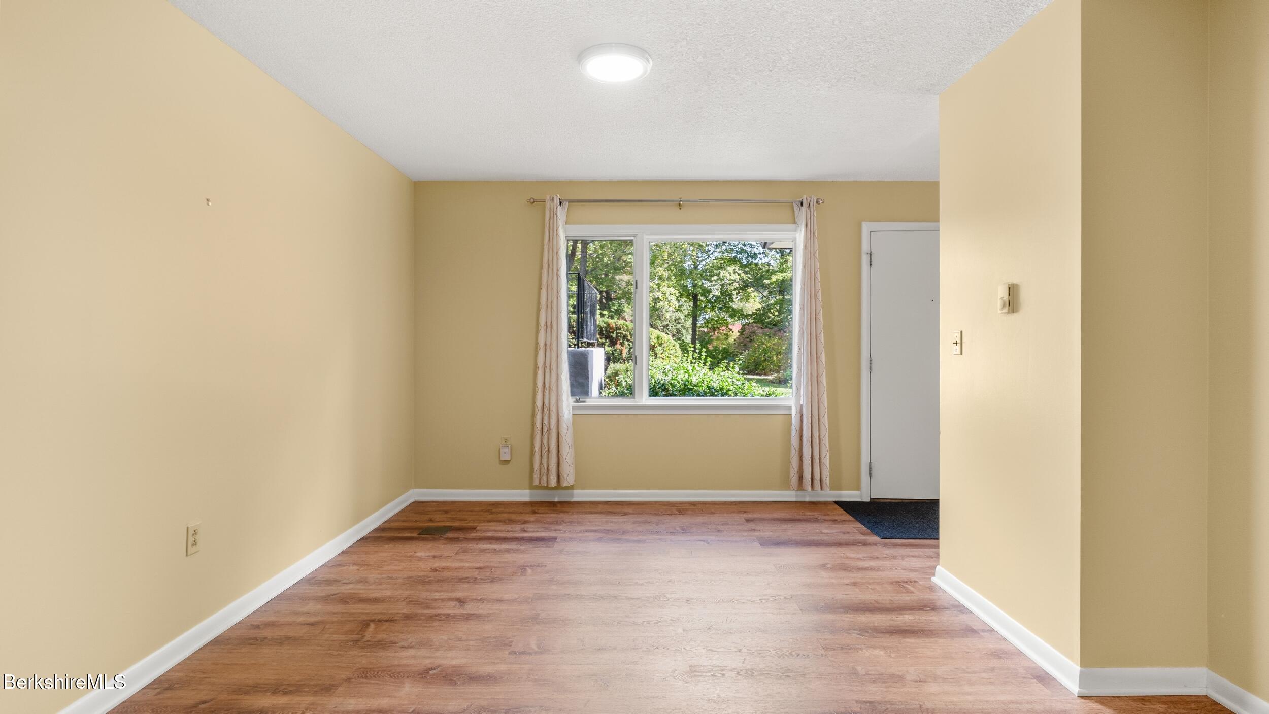 1 Colt Road, Unit 2 Pittsfield, MA 01201 - Photo 9 of 20 a view of an empty room with wooden floor and a window