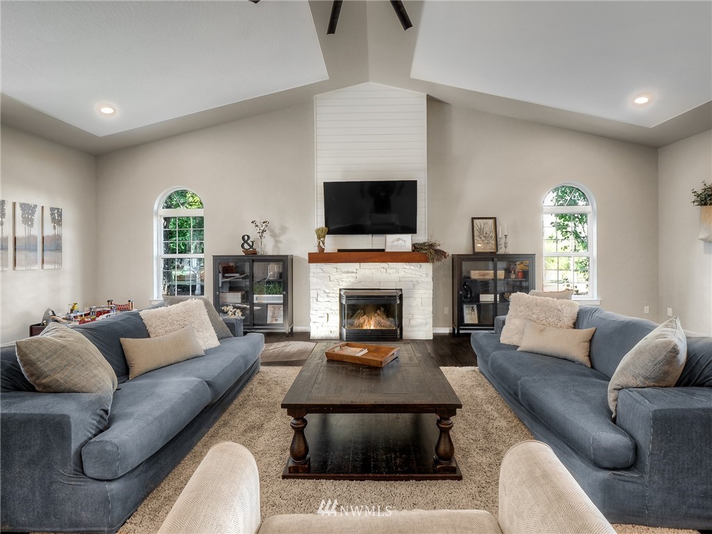 5060 133rd Avenue Southwest Rochester, WA 98579 - Photo 14 of 40 a living room with furniture a flat screen tv and a fireplace