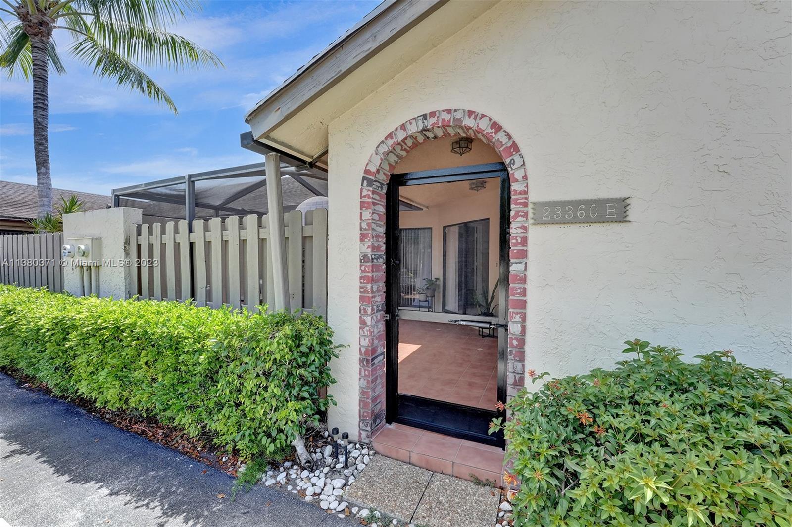 23360 Southwest 53rd Avenue, Unit E Boca Raton, FL 33433 - Photo 1 of 37 a front view of a house with garden