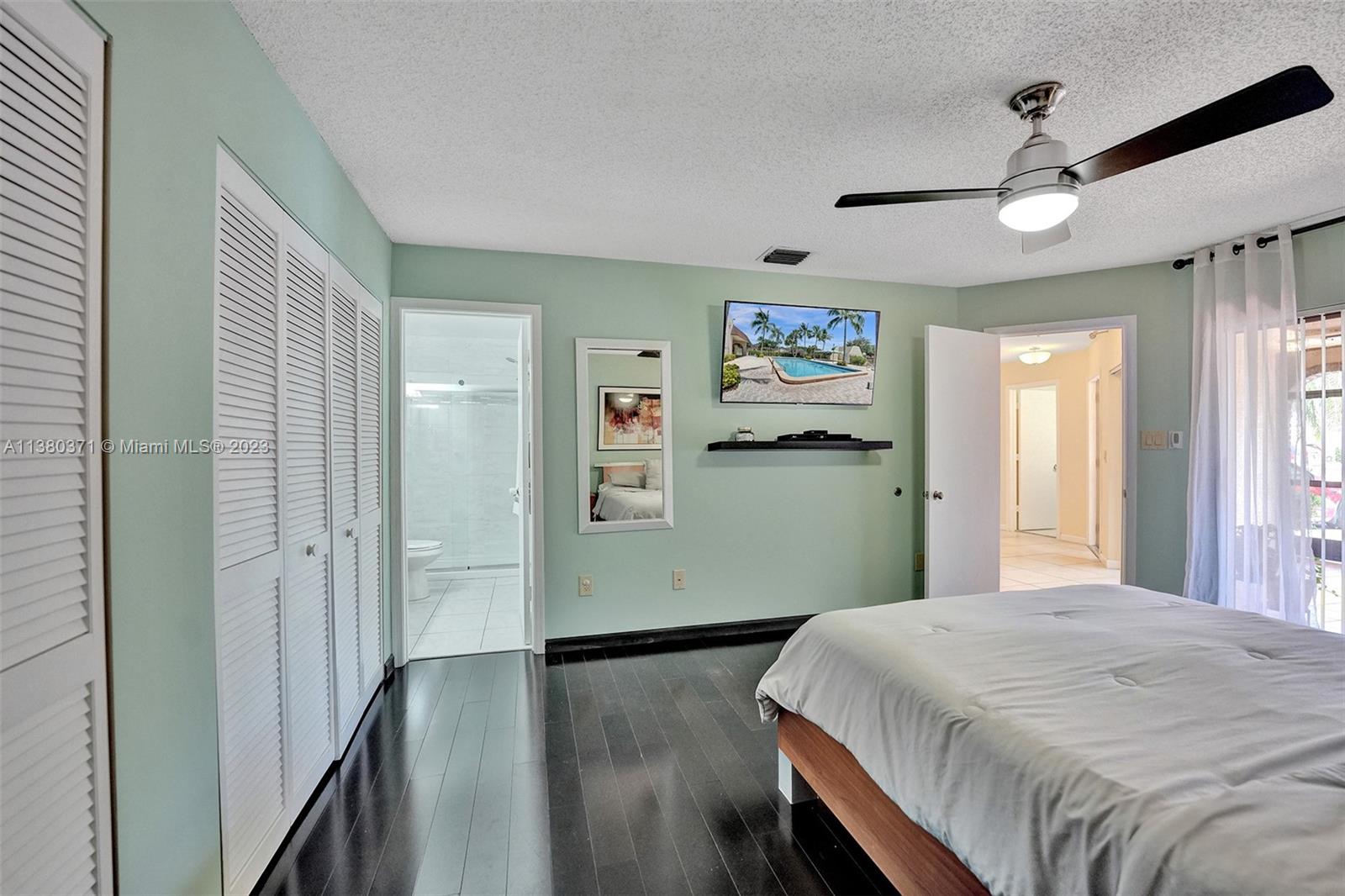 23360 Southwest 53rd Avenue, Unit E Boca Raton, FL 33433 - Photo 15 of 37 a bedroom with a bed and a painting on the wall